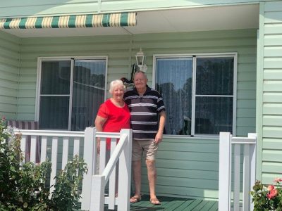 retired couple in front of their park home